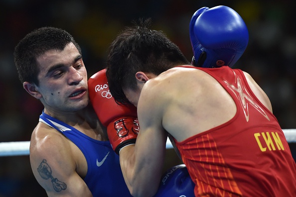 China's Hu Jianguan (R) fights Armenia's Narek Abgaryan during the Men's Fly (52kg) match at the Rio 2016 Olympic Games at the Riocentro - Pavilion 6 in Rio de Janeiro on August 15, 2016. / AFP / YURI CORTEZ (Photo credit should read YURI CORTEZ/AFP/Getty Images)